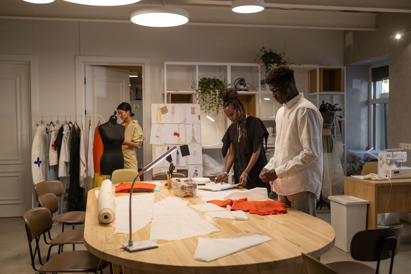 A small design team working together around a cutting table in their studio.